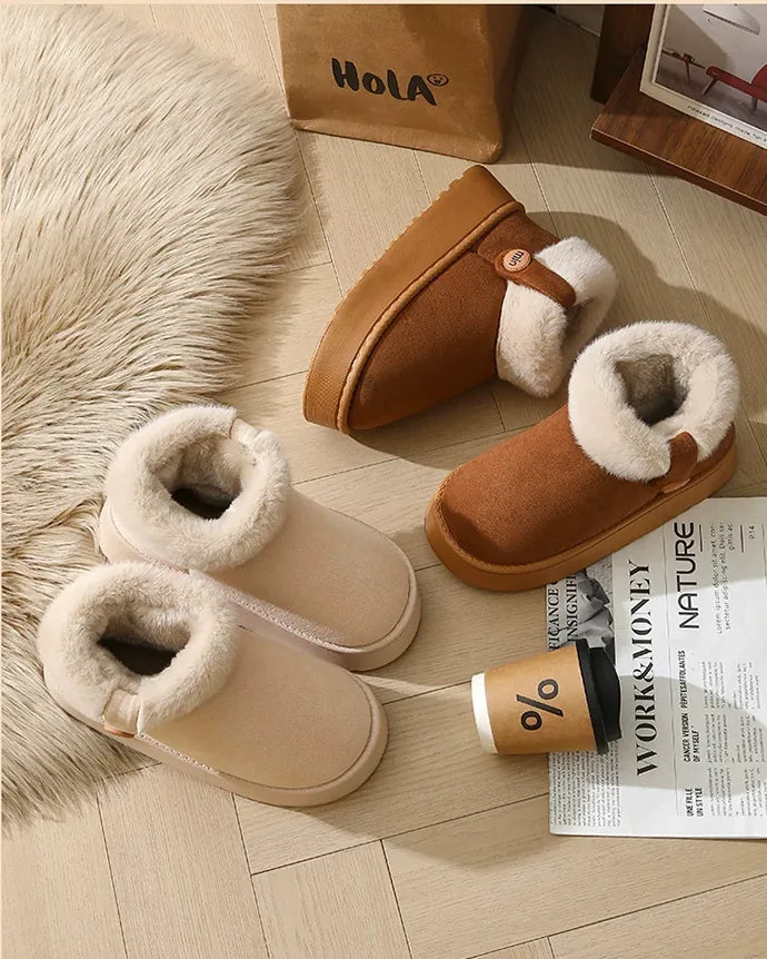 Ivory white and dark brown boots laid on a rug with a coffee cup and a magazine