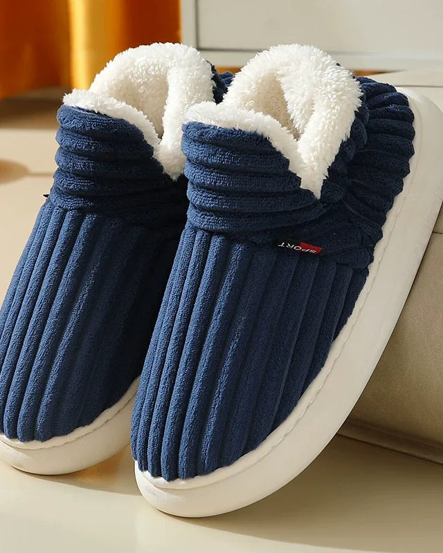 Pair of navy blue ribbed plush slipper boots with a cream fleece collar and a white sole
