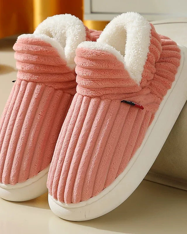 Pair of pink ribbed plush slipper boots with a cream fleece collar and a white sole